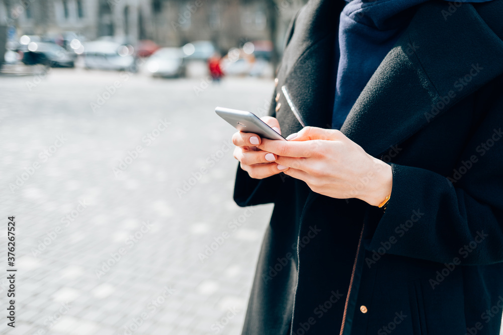 Woman wearing black coat using smart phone Woman wearing black coat using smart phone