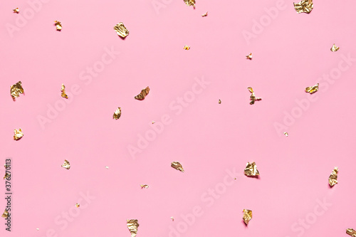 Shiny golden sparkles foil confetti on pink holiday festive background. 