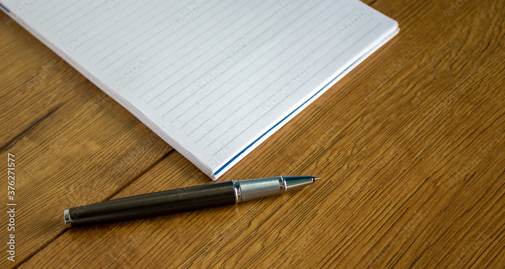 Notebook and pen on wood table. Business and education concept. Notebook and pen on wood table. Business and education concept.