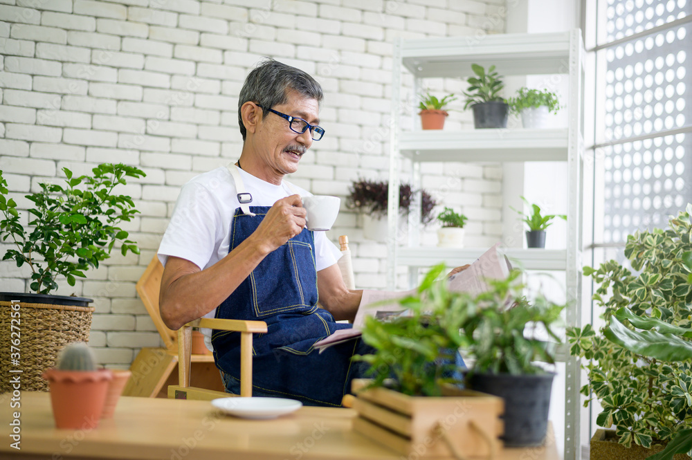 An elderly man is relaxing with coffee and reading Newspaper at his home . An elderly man is relaxing with coffee and reading Newspaper at his home .