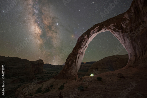 Camping tent underneath Corona Arch and the Milky Way Galaxy photo