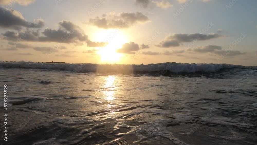 Ocean waves. Calm waves at sunset from a low point of view. The water hit the camera lens.
