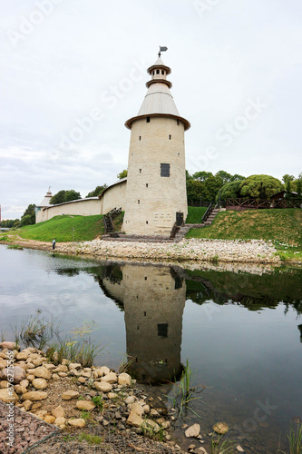 Beautiful view to tall tower of Pskov kremlin  krom  with reflection in water and rivers Pskova and velikaya