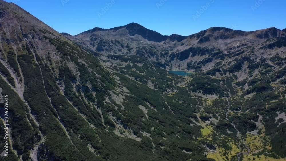 Amazing alpine lake at the mountains, high alpine green peak, sunny summer day, drone flight. Amazing alpine lake at the mountains, high alpine green peak, sunny summer day, drone flight.