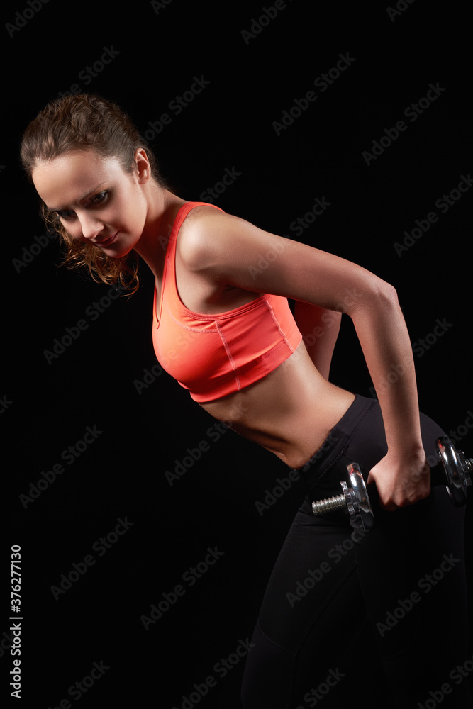 pretty caucasian fitness woman on black isolated background in studio