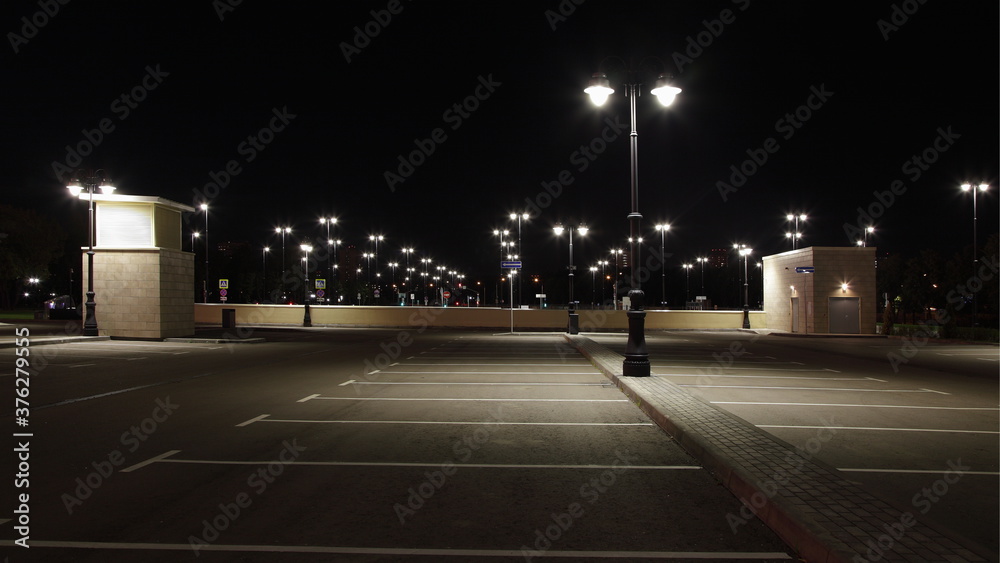 Empty outdoor contemporary Moscow car Parking with streetlights in family children's Park Island of Dreams on Andropova avenue on a summer night