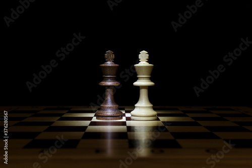 chess pieces on chessboard on black background