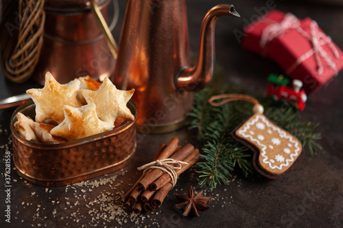 Traditional Christmas Homemade Star Shaped Cookies surrounded by Christmas decor, cinnamon and copper utensils. Close-up, selective focus. Still life in vintage style
