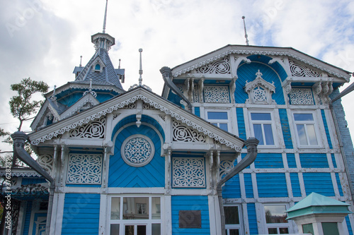 Vintage beautiful wooden house with carved wood frames in the city of Tomsk city, Russia. Russian folk style in architecture.  photo