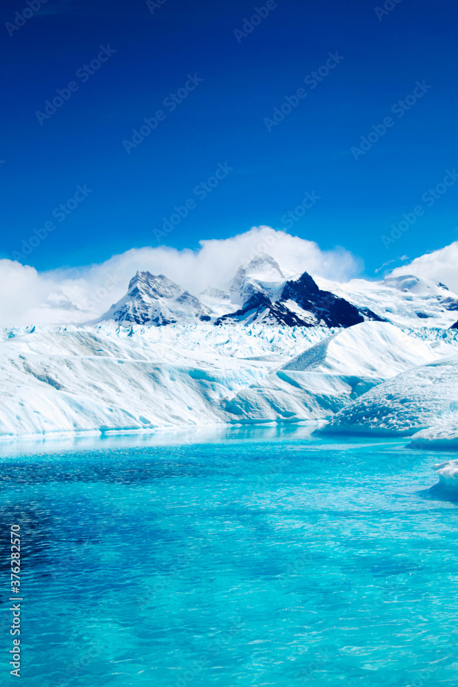 Lake on glacier with mountainous background.