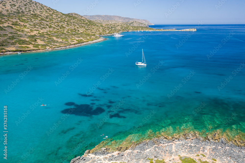 Sailing boats and yachts in the crystal clear waters of the Aegean Sea (Crete, Greece)
