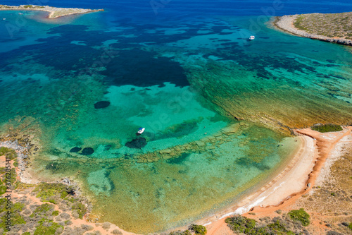 Aerial view of a small island and boats in a crystal clear blue ocean (Kolokitha, Elounda, Crete, Greece)