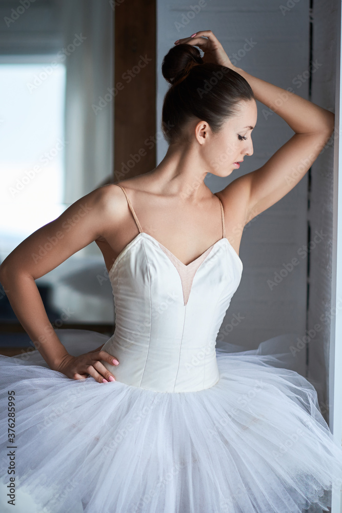 Side view of beautiful ballerina standing and looking through window. Copyspace Side view of beautiful ballerina standing and looking through window. Copyspace