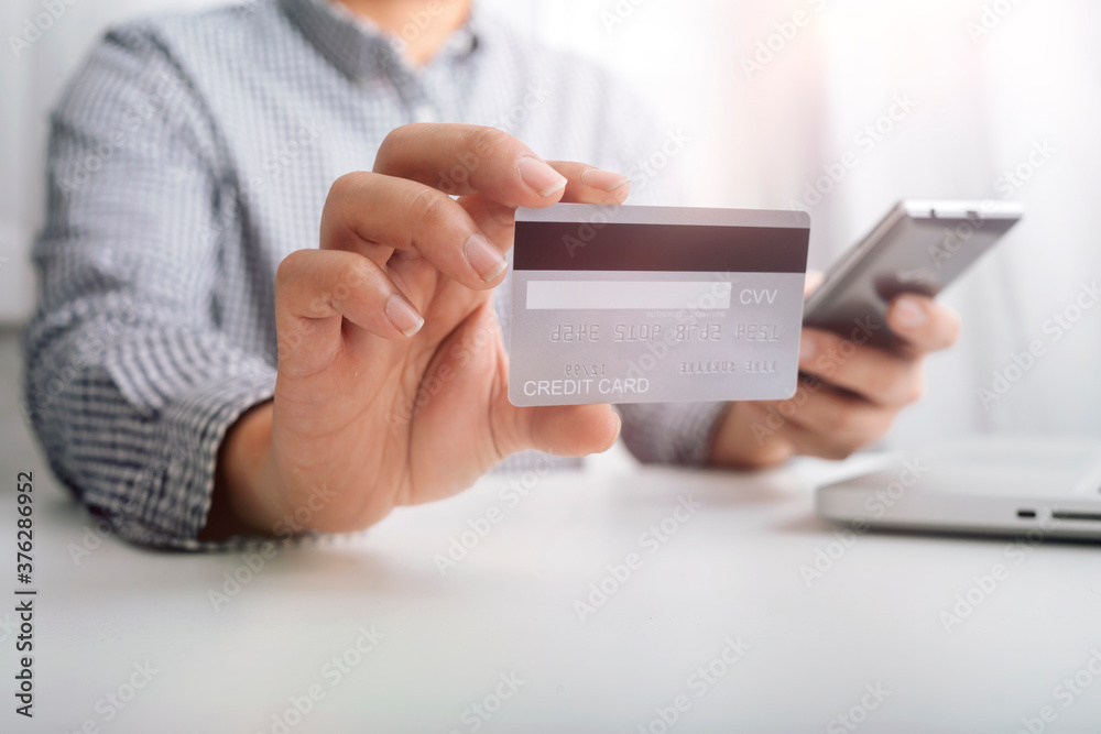 Business people use tablets and hold credit cards as an online shopping concept With a calculator and a book placed on the table Business people use tablets and hold credit cards as an online shopping concept With a calculator and a book placed on the table
