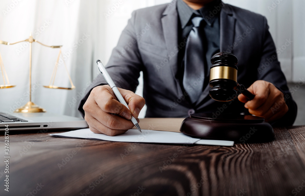 Business and lawyers discussing contract papers with brass scale on desk in office. Law, legal services, advice, justice and law concept picture with film grain effect Business and lawyers discussing contract papers with brass scale on desk in office. Law, legal services, advice, justice and law concept picture with film grain effect