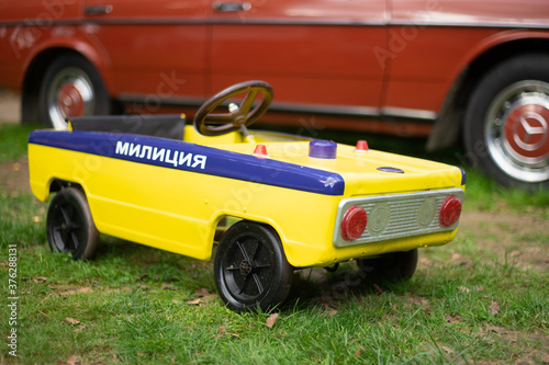 Old yellow toy car with russian writing designating it as Militia (  Militsiya), the analog of police.