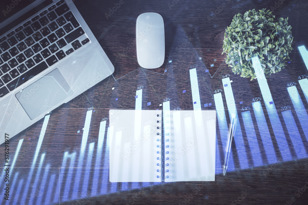 Stock market graph and top view computer on the table background. Double exposure. Concept of financial education. Stock market graph and top view computer on the table background. Double exposure. Concept of financial education.