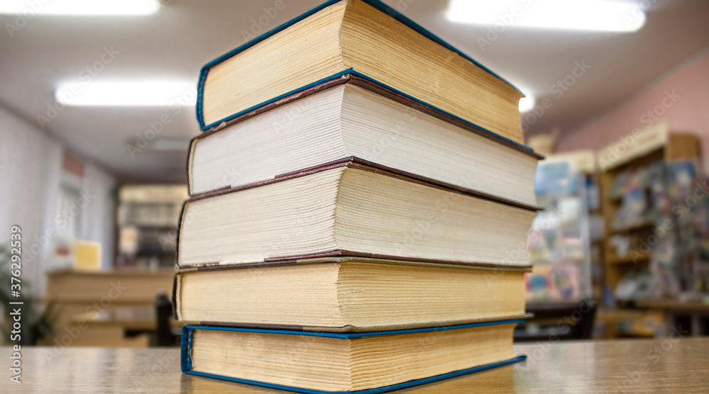Old books on a wooden shelf with blurred backgrund Old books on a wooden shelf with blurred backgrund