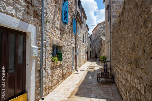 Fototapeta Naklejka Na Ścianę i Meble -  Stari Grad/ Croatia-August 7th, 2020: Narrow dalmatian streets all covered in stone at the oldest town on Hvar island