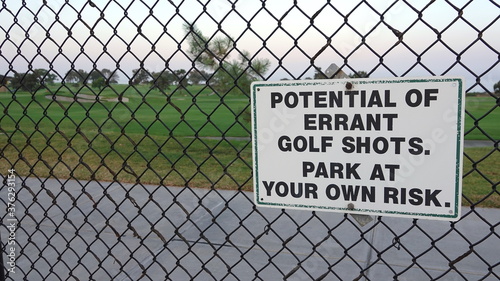 A sign at the parking lot of a golf course warns of damage caused by errant balls 