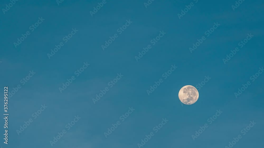 Close-up setting full moon moves in the blue sky at sunrise. 4k time-lapse Close-up setting full moon moves in the blue sky at sunrise. 4k time-lapse