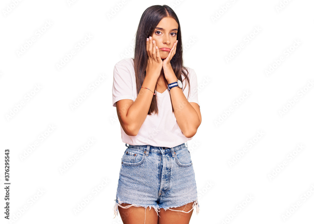 Young hispanic woman wearing casual white tshirt tired hands covering face, depression and sadness, upset and irritated for problem Young hispanic woman wearing casual white tshirt tired hands covering face, depression and sadness, upset and irritated for problem