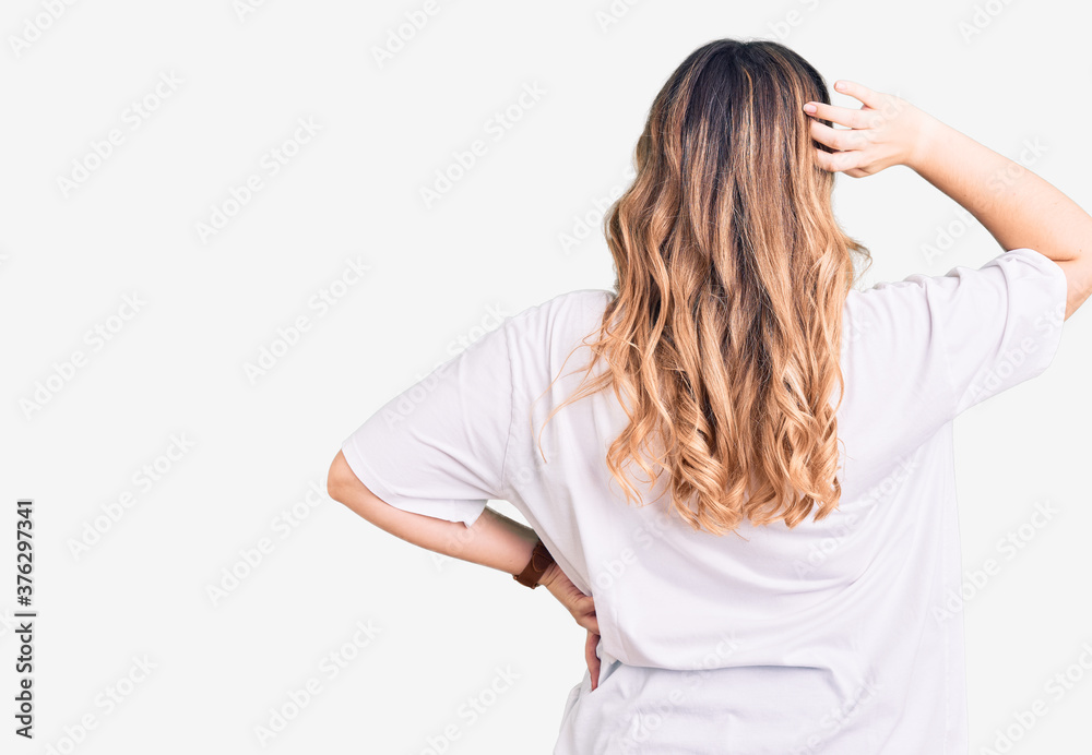 Young caucasian woman wearing casual clothes backwards thinking about doubt with hand on head Young caucasian woman wearing casual clothes backwards thinking about doubt with hand on head