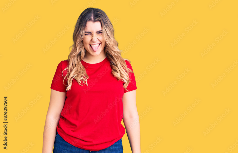 Young caucasian woman wearing casual clothes sticking tongue out happy with funny expression. emotion concept. Young caucasian woman wearing casual clothes sticking tongue out happy with funny expression. emotion concept.