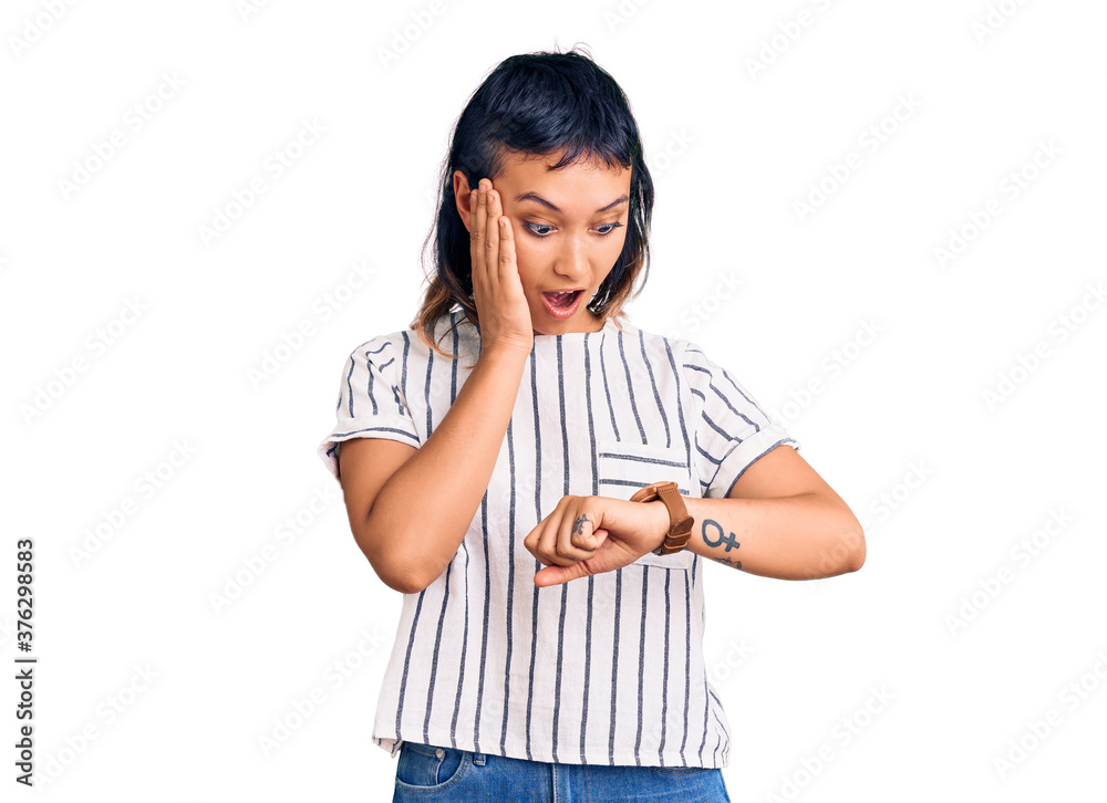 Young woman wearing casual clothes looking at the watch time worried, afraid of getting late Young woman wearing casual clothes looking at the watch time worried, afraid of getting late