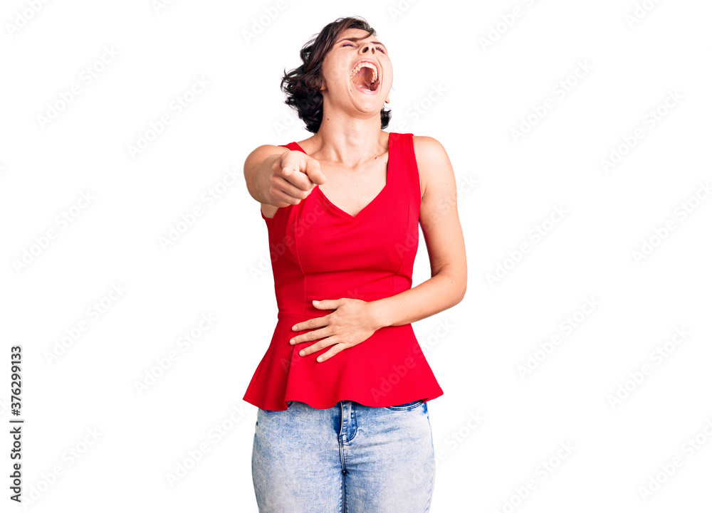 Fototapeta premium Beautiful young woman with short hair wearing casual style with sleeveless shirt laughing at you, pointing finger to the camera with hand over body, shame expression
