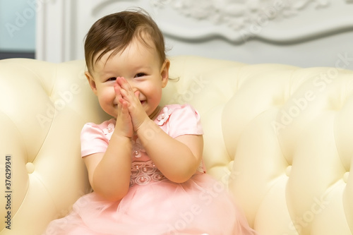 Charming little girl laughing happily in studio