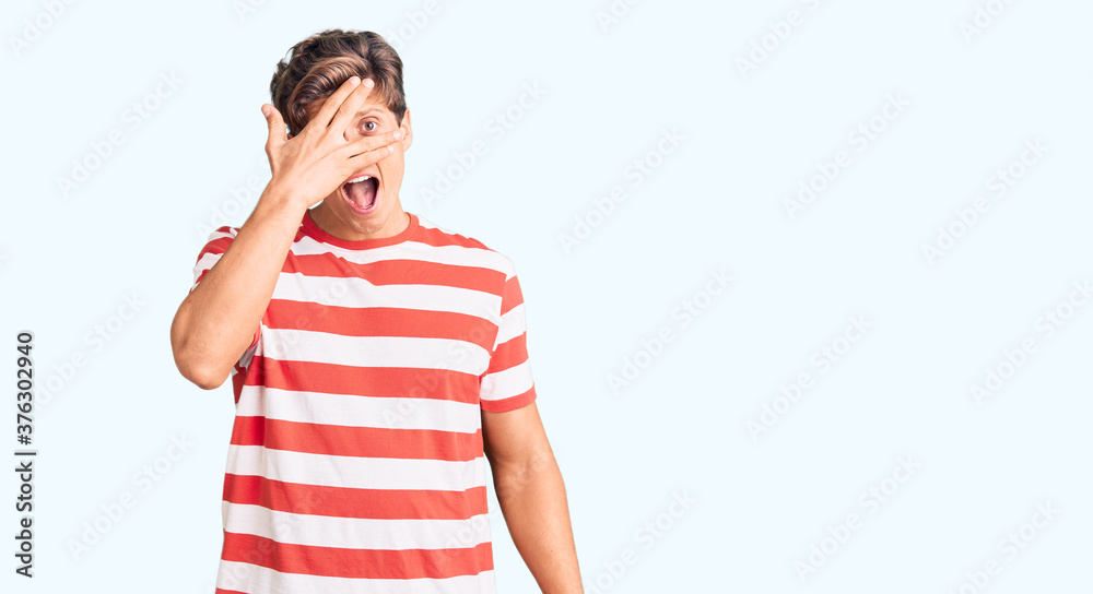 Young handsome man wearing casual clothes peeking in shock covering face and eyes with hand, looking through fingers with embarrassed expression. Young handsome man wearing casual clothes peeking in shock covering face and eyes with hand, looking through fingers with embarrassed expression.