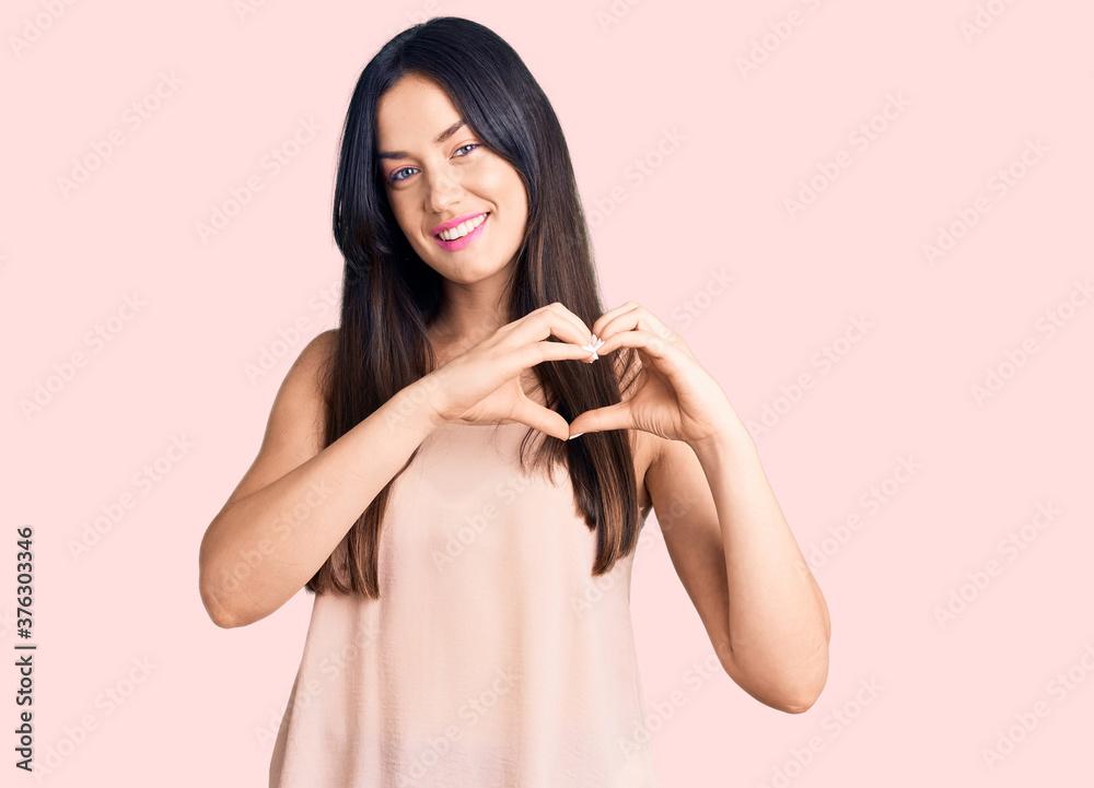 Young beautiful caucasian woman wearing casual clothes smiling in love showing heart symbol and shape with hands. romantic concept. Young beautiful caucasian woman wearing casual clothes smiling in love showing heart symbol and shape with hands. romantic concept.