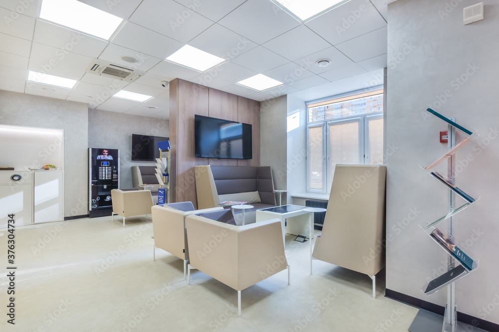 Trendy and modern office in white colors with the waiting area for clients .The coffee wending machine next to the coffee point. Trendy and modern office in white colors with the waiting area for clients .The coffee wending machine next to the coffee point.