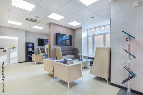 Trendy and modern office in white colors with the waiting area for clients .The coffee wending machine next to the coffee point. photo