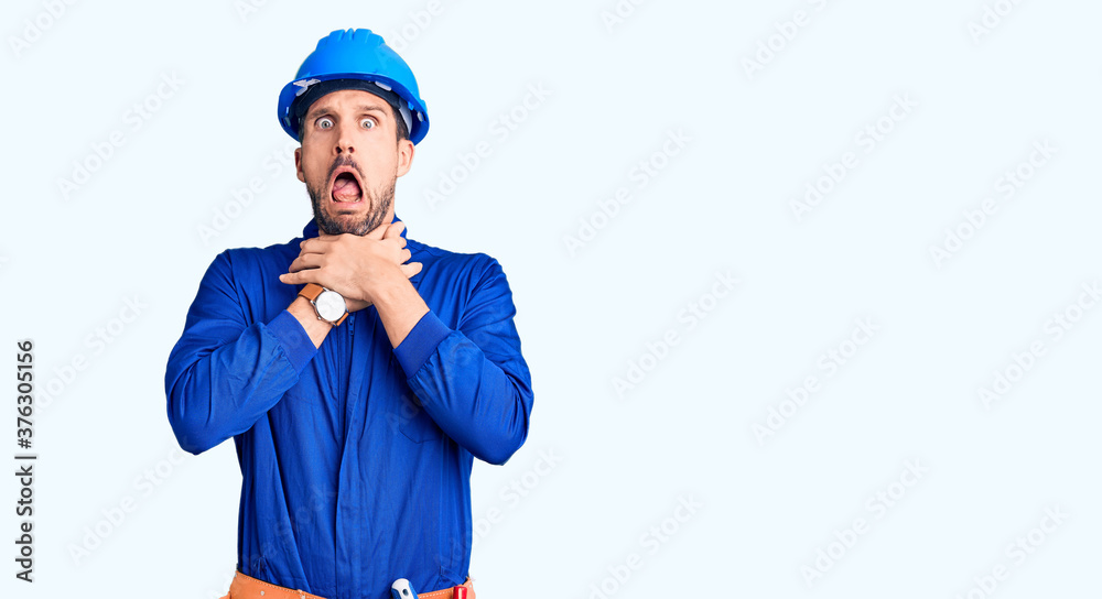 Young handsome man wearing worker uniform and hardhat skeptic and nervous, disapproving expression on face with crossed arms. negative person. Young handsome man wearing worker uniform and hardhat skeptic and nervous, disapproving expression on face with crossed arms. negative person.