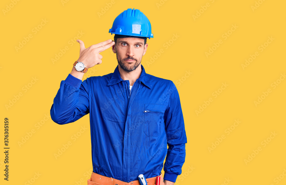 Young handsome man wearing worker uniform and hardhat looking stressed and nervous with hands on mouth biting nails. anxiety problem.