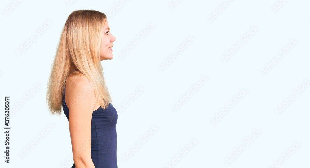 Young beautiful blonde woman wearing casual dress looking to side, relax profile pose with natural face with confident smile. Young beautiful blonde woman wearing casual dress looking to side, relax profile pose with natural face with confident smile.