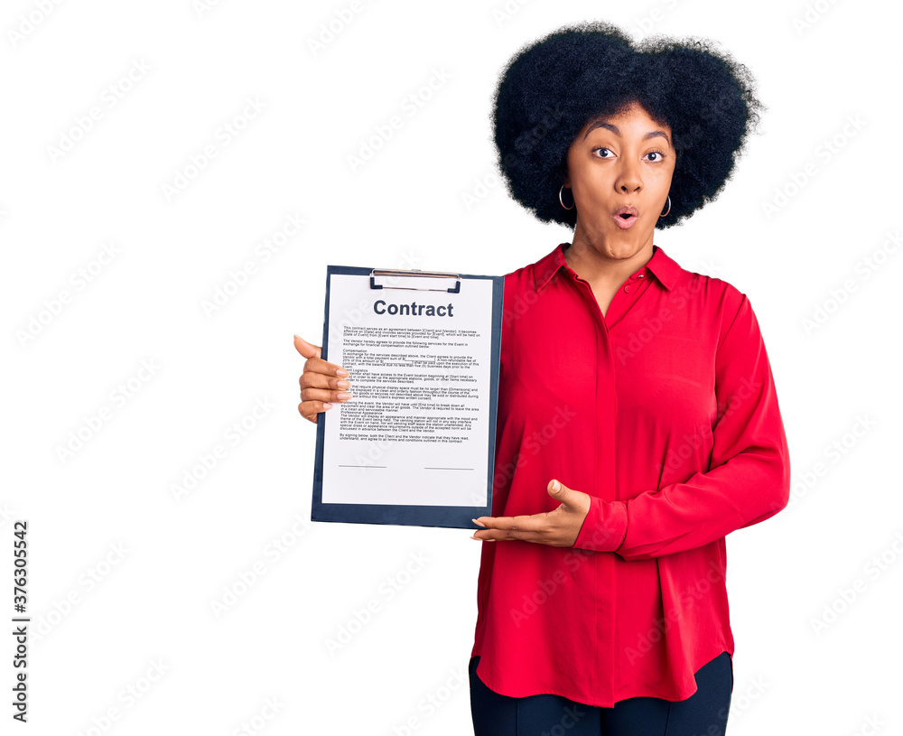 Young african american girl holding clipboard with contract document scared and amazed with open mouth for surprise, disbelief face Young african american girl holding clipboard with contract document scared and amazed with open mouth for surprise, disbelief face