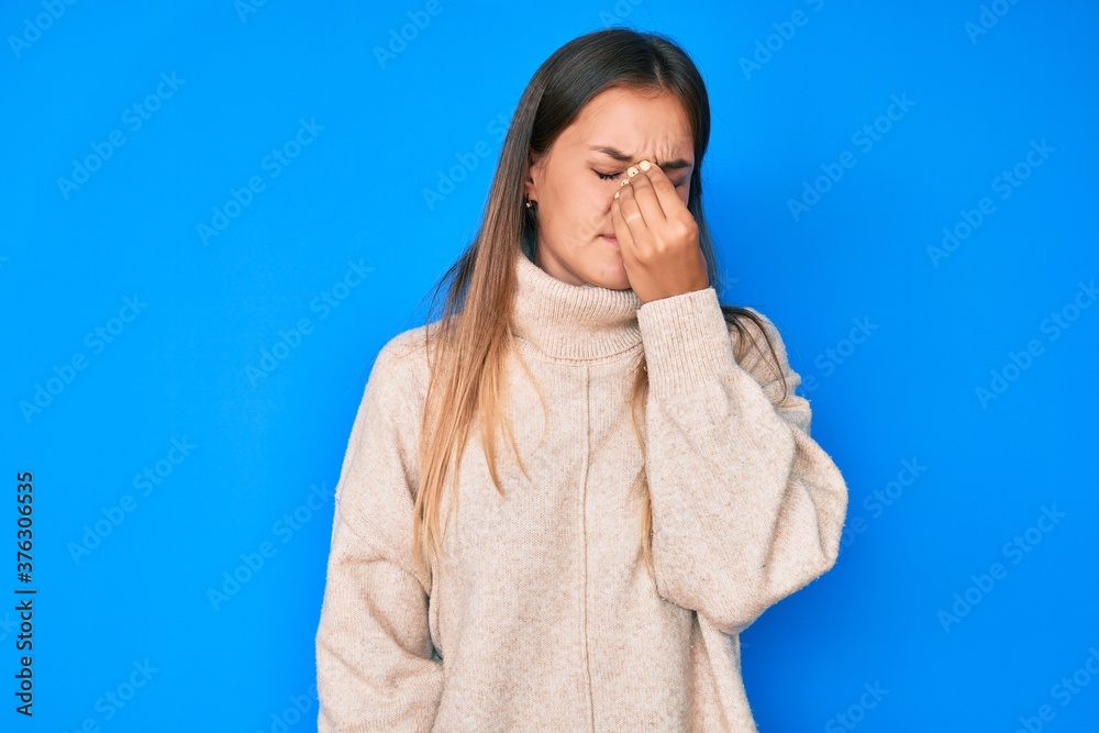 Beautiful caucasian woman wearing wool winter sweater tired rubbing nose and eyes feeling fatigue and headache. stress and frustration concept. Beautiful caucasian woman wearing wool winter sweater tired rubbing nose and eyes feeling fatigue and headache. stress and frustration concept.