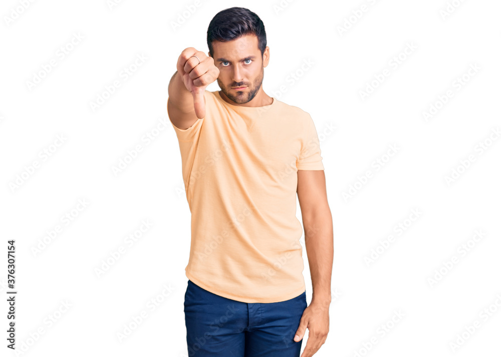 Fototapeta premium Young hispanic man wearing casual clothes looking unhappy and angry showing rejection and negative with thumbs down gesture. bad expression.