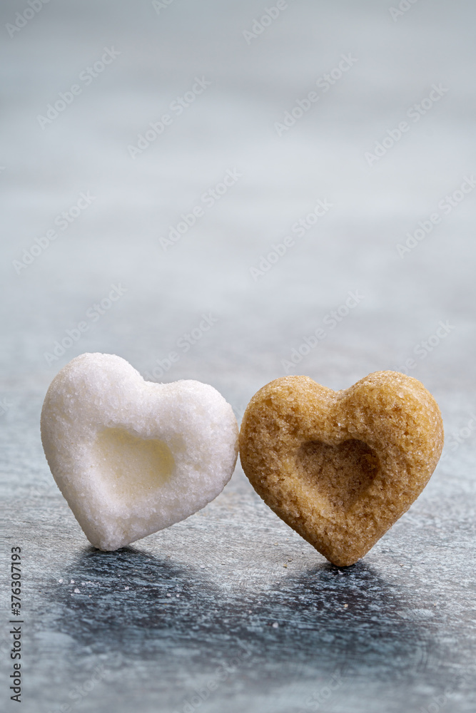 Obraz premium A pair of heart-shaped sugar cubes. Interracial relationship metaphor