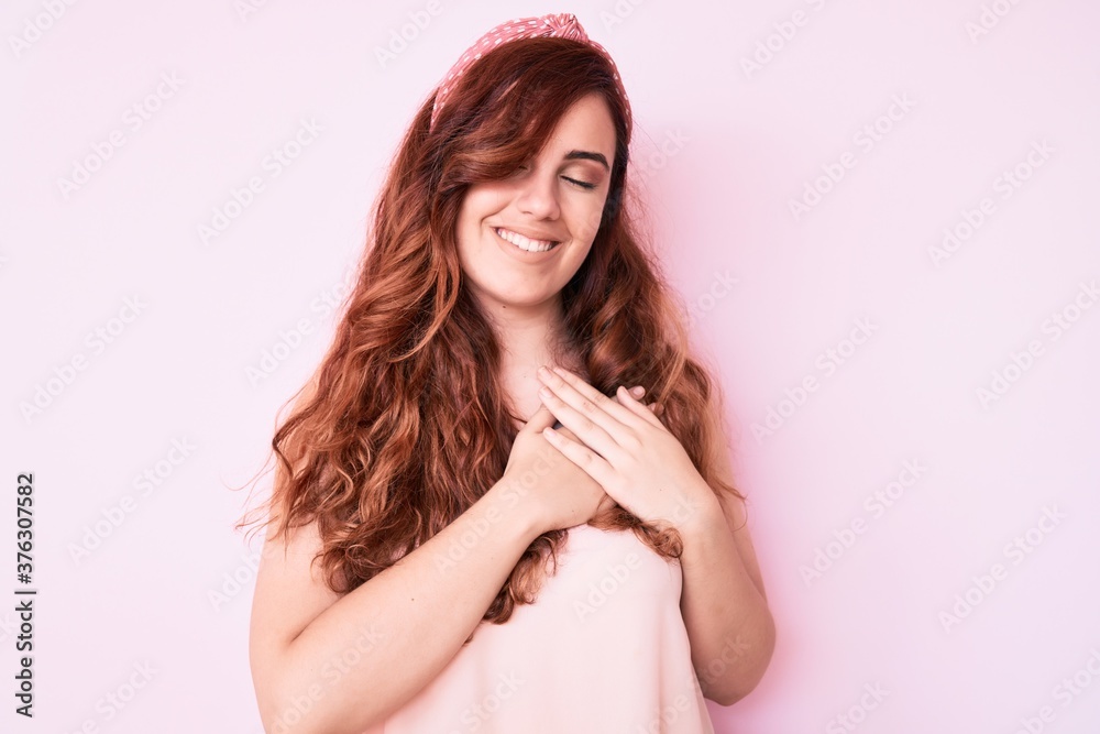 Young beautiful woman wearing casual clothes smiling with hands on chest with closed eyes and grateful gesture on face. health concept. Young beautiful woman wearing casual clothes smiling with hands on chest with closed eyes and grateful gesture on face. health concept.