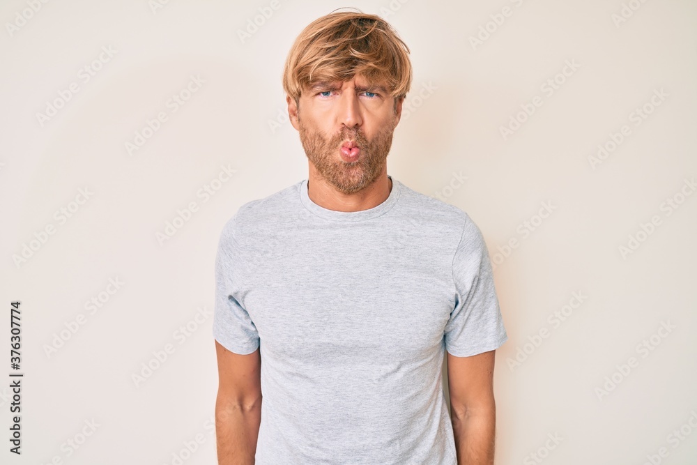 Young blond man wearing casual clothes making fish face with lips, crazy and comical gesture. funny expression. Young blond man wearing casual clothes making fish face with lips, crazy and comical gesture. funny expression.