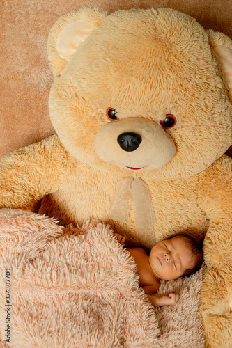 Two week old newborn baby sleeping on teddy bear © volody10