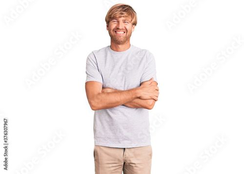 Handsome caucasian man with beard wearing casual tshirt happy face smiling with crossed arms looking at the camera. positive person.