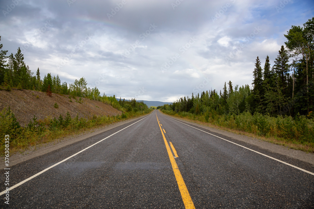 Beautiful View of a scenic road, Alaska Highway, in the Northern Rockies during a sunny and cloudy morning sunrise. Taken in British Columbia, Canada. Nature Background