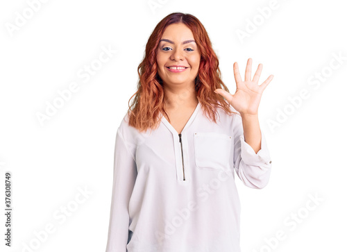 Young latin woman wearing casual clothes showing and pointing up with fingers number five while smiling confident and happy.