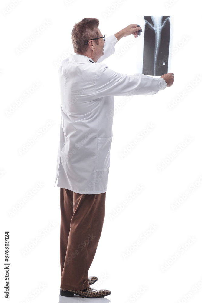 male doctor looking at an x- ray of a patient. isolated on a white male doctor looking at an x- ray of a patient. isolated on a white