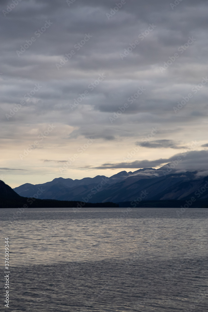 Beautiful View of Muncho Lake in the Canadian Northern Rockies during a cloudy sunrise. Taken in British Columbia, Canada. Nature Background